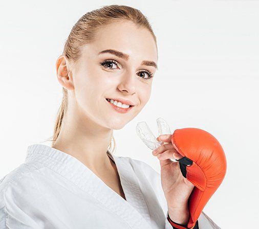 Teen girl placing atheltic mouthguard